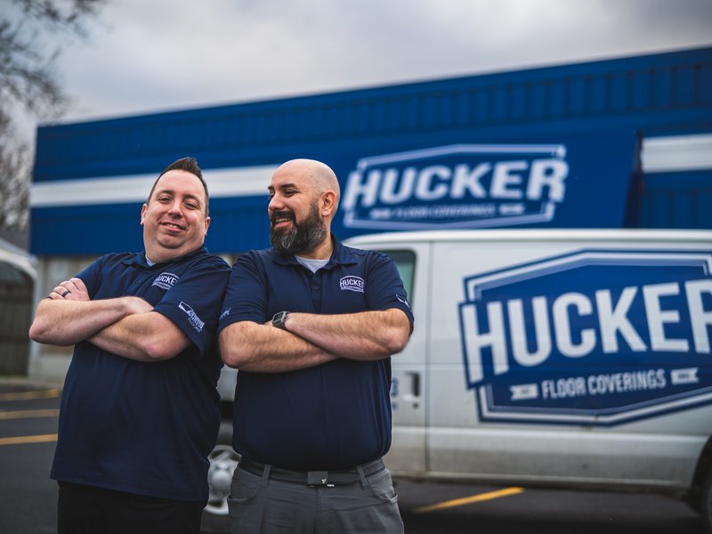 Hucker Floor Coverings Owners in front of van and store