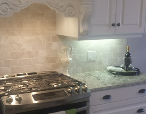 Kitchen with light backsplash and white cabinets