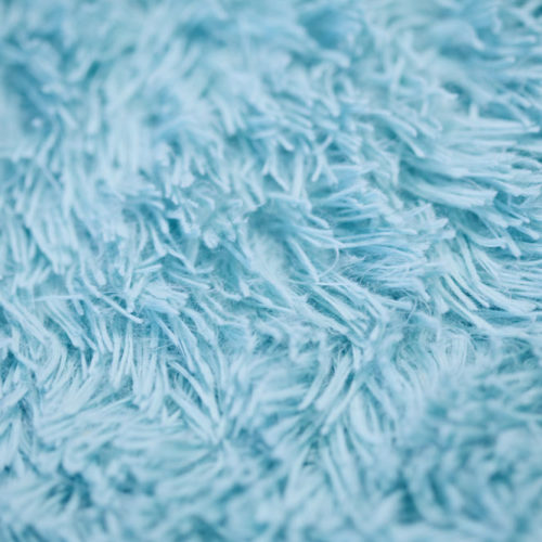 Close up of a light blue shag style carpet